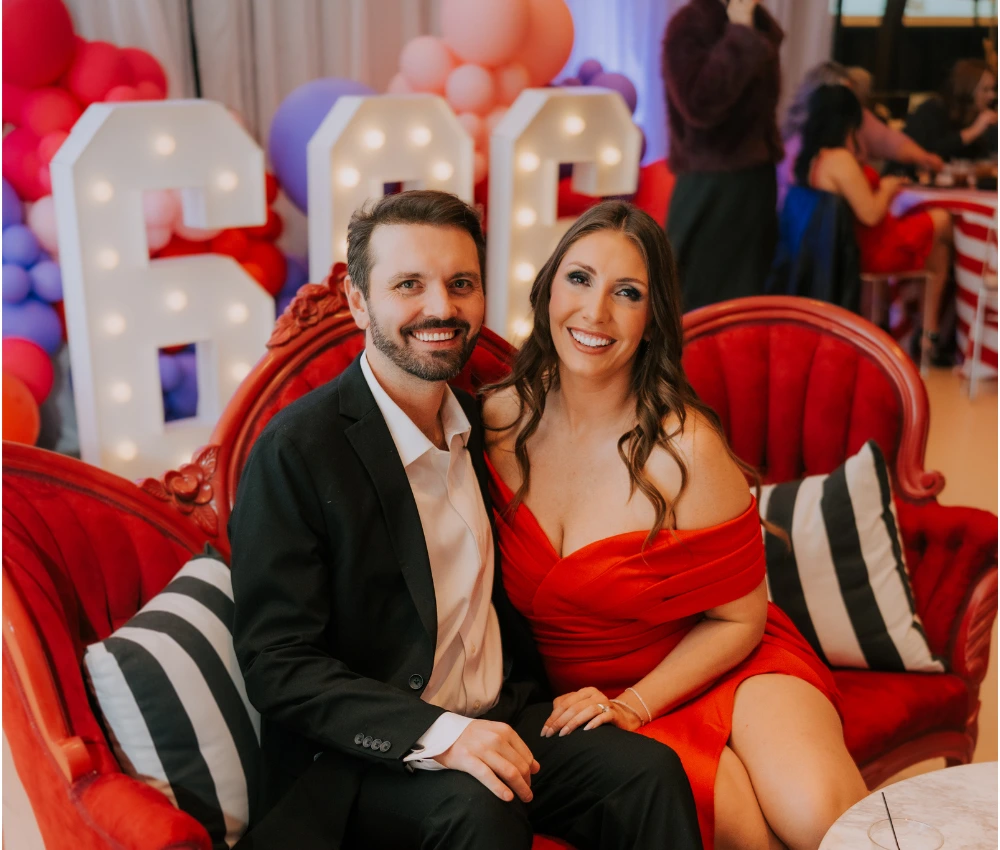 Eventgoers in formalwear posing for a photo by a 606 background