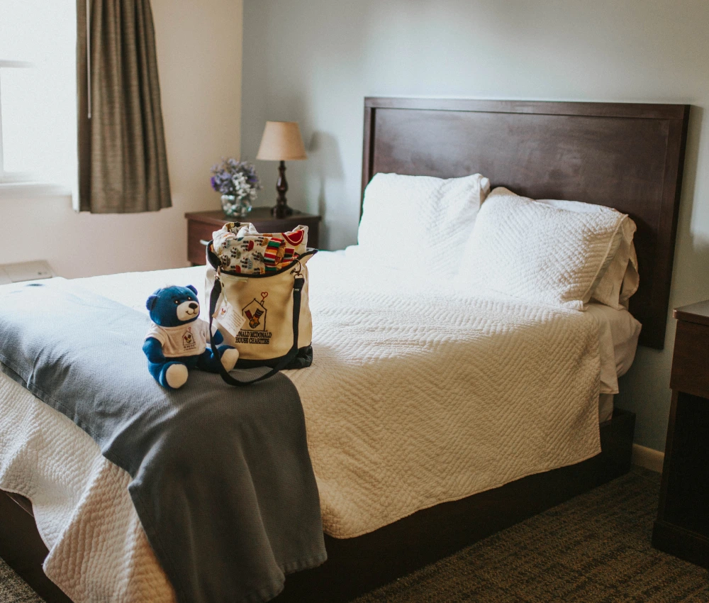 guest room with gift bag and teddy bear waiting on bed